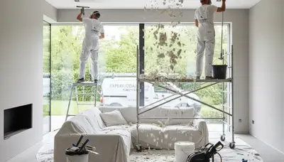 Painter removing popcorn ceiling in Minneapolis MN home for smooth finish and modern interior update